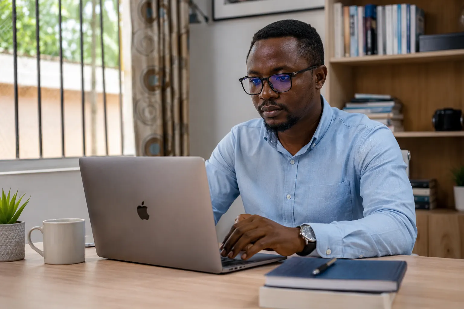 Professionnel camerounais en télétravail à la maison sur un ordinateur portable